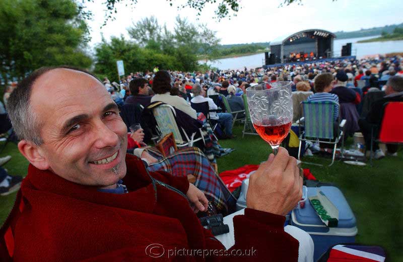 man at music concert eventdrinking wine at Carsington Water derbyshire. photograph taken for press release for severn trent water by mike kelly photographer picturepress.