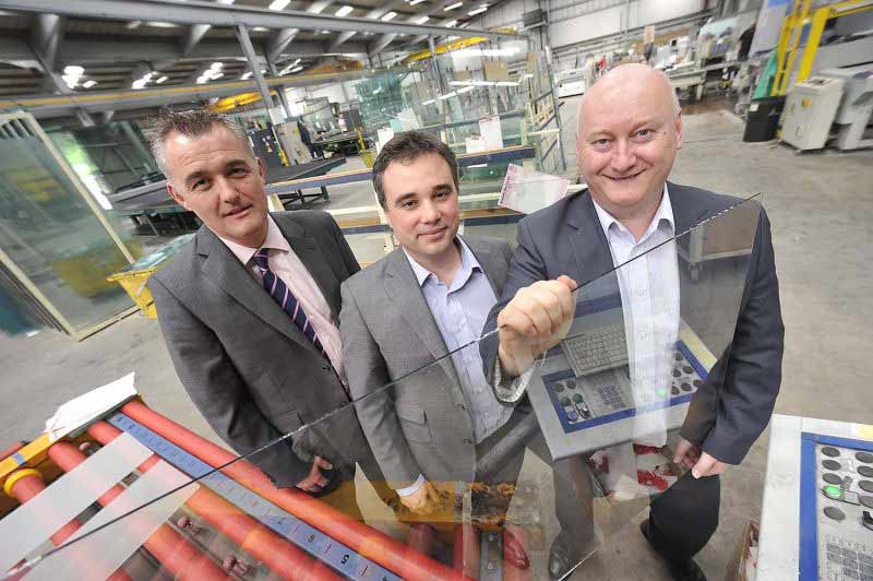 Three men holding sheet of glass in glass factory.  image taken for news release. by picturepress  photography birmingham